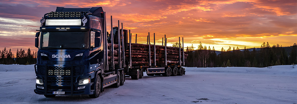 Scanialastbil i solnedgång